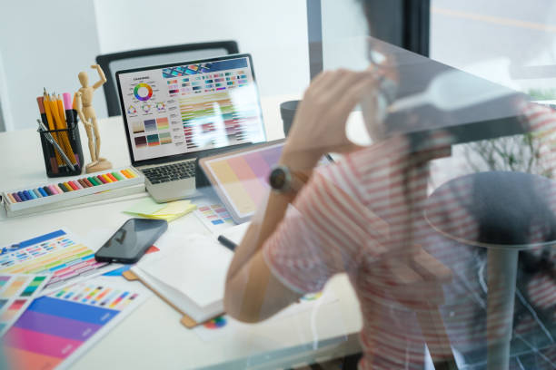 istock View through glass window of creative woman working in modern office. 1628270003