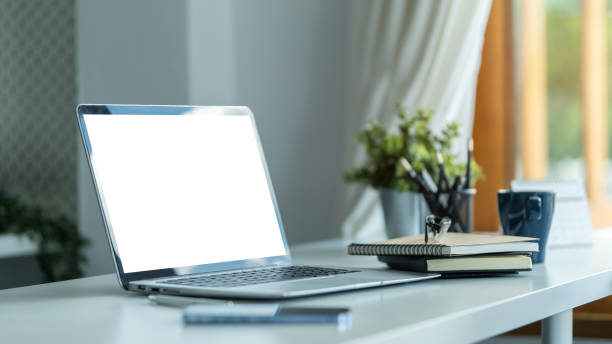 istock Computer laptop with empty screen, coffee cup, and potted plant on table. Home office. 1628279359