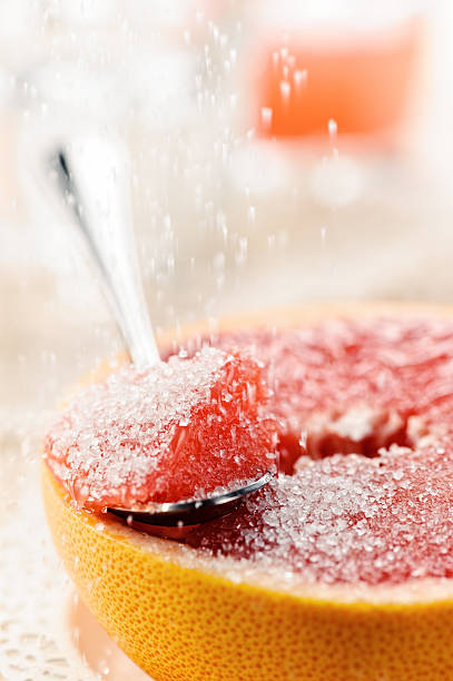 Piece of red grapefruit with sugar, fruit dessert stock photo