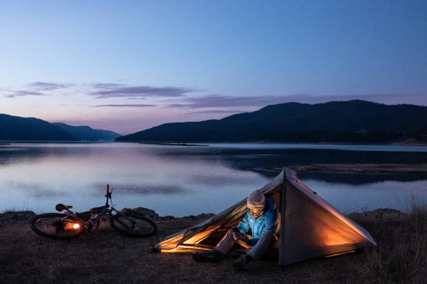 istock People and nature. Man camping at lakeshore. 1628283573