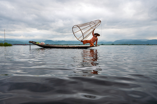 Roi-Et Province, Thailand - March 10: Continuous photographic image 1 out of 15 pictures of villagers standing and casting fishing nets in the middle of the swamp.