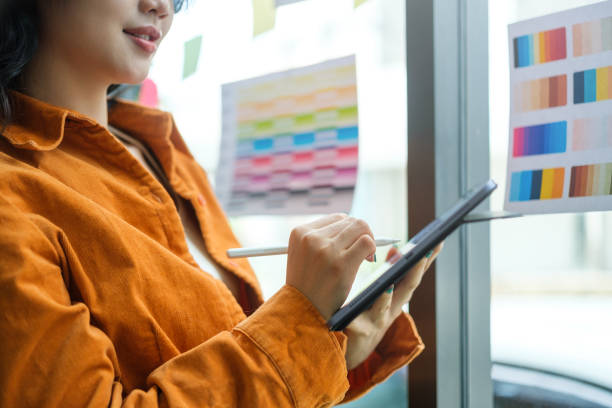 istock Young creative woman working on color selection and drawing on digital tablet at workplace. 1628317001