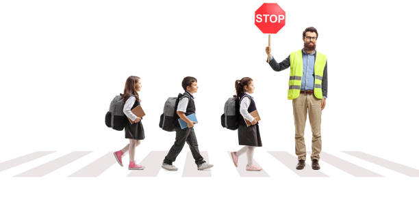 man with a stop sign and and children crossing a street at a pedestrian crosswalk - street fog profile imagens e fotografias de stock
