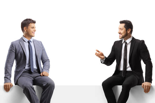 istock Businessmen sitting on a blank panel and having a conversation 1628317519
