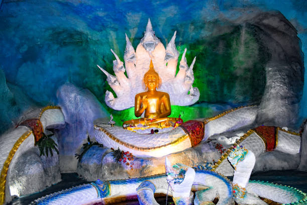 wat sawat niwet, magic cave, Phrae, Northwest Thailand, gilded statue of sitting buddha on a big snake, coiling snake, vitarka mudra, hand gesture of teaching and discussion, statue of a snake with nine heads behind the buddha statue, artwork, crafts, attraction, point of interest