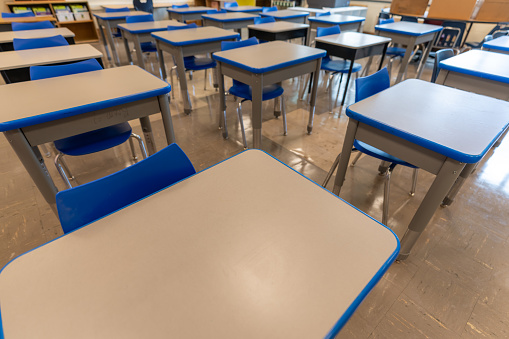 Example of an empty nondescript US High School Classroom with desks.