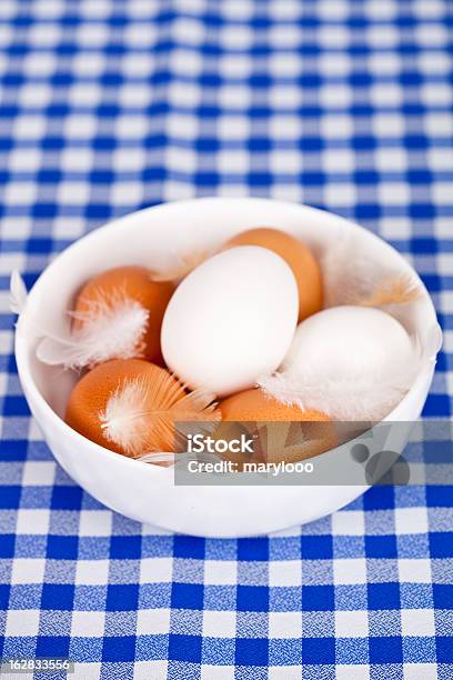 Huevos Feathers En Un Tazón Sobre Fondo Mantel Foto de stock y más banco de imágenes de Alimento - Alimento, Azul, Blanco - Color