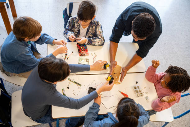 istock High angle view of male teacher giving instructions to his class during robotics class while they all pay attention 1628348235