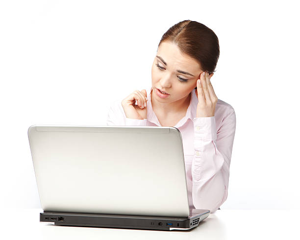 Young woman sitting at a laptop, on the white background. stock photo