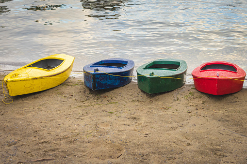 4 canoes sit on the beach of a lake in Vermont