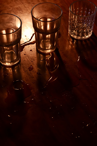 Light and shadow of drinking glass on wooden table