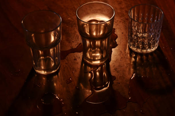 istock Light and shadow of drinking glass on wooden table 1628385224