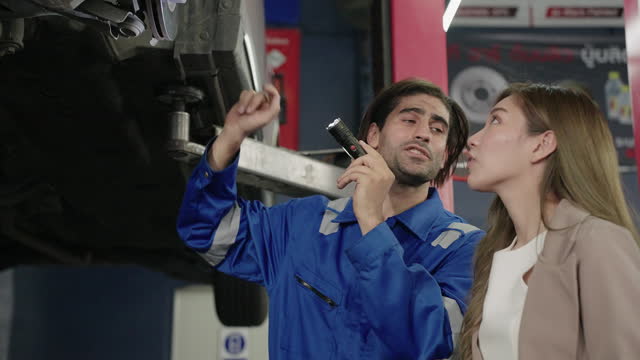 Auto Repair Consultation: Mechanic Explains to Woman Customer at Garage