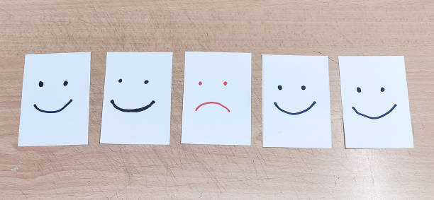 istock Happy face drawn on white papers. Think positive and satisfaction level concept. 1628421234