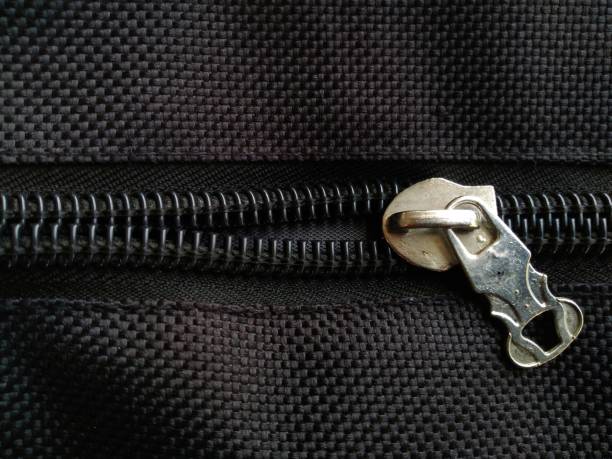istock Metallic zipper on black fabric. 1628425446