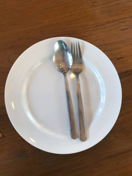 istock Empty plate with spoon and fork on the wooden table, stock photo 1628425448