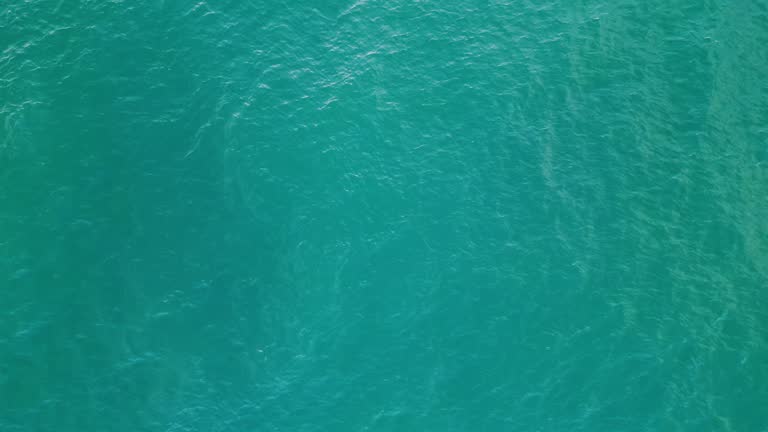 Turquoise water waving agitated aerial view. Blue sea surface making small waves