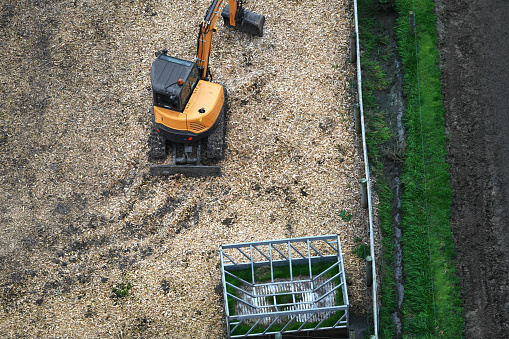Small Excavator Digger operating within a livestock pen, adding in various tasks in the animal enclosure.