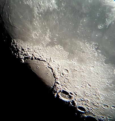 Partly illuminated moon in the dark night sky over Western Europe on January 18, 2024. The surface of the moon is clearly visible with various craters and seas.