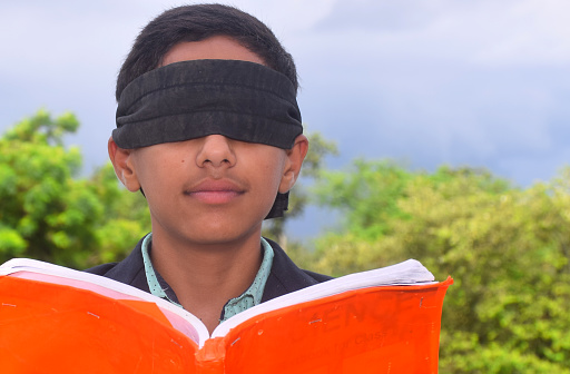 13 year old child with blindfold reading book, on the roof in the rainy season, Indecision and uncertainty conceptual, selective focus