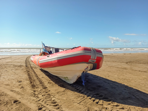 Rigid hull inflatable boat with outboard motor in the shore. Used to fish at sea