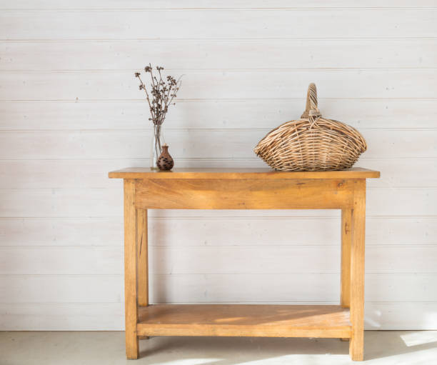 istock Oak side table with accessories including seedpod, dried twigs and wicker basket 1628581948