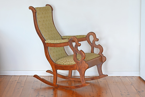 Old antique wooden rocking chair on a wooden floor