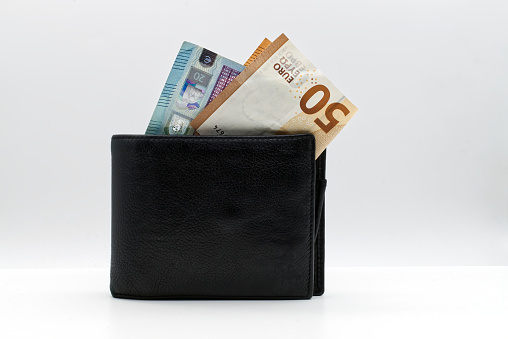Black leather wallet with euro banknotes isolated on white background.