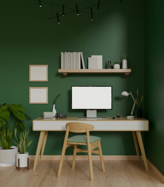 istock Modern trendy workspace with a computer on a minimal wooden desk against the green wall 1628684457