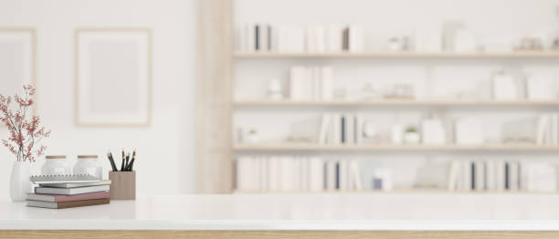 Copy space on a luxury white tabletop over a blurred modern white living room with large bookshelves