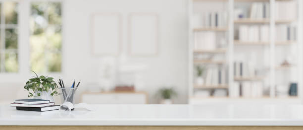 istock Copy space on a white table over a blurred modern white living room in the background. 1628684978