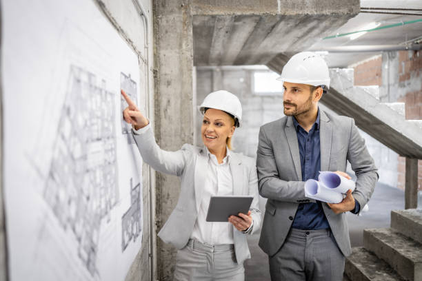 istock Construction inspectors working together at the site, controlling and inspecting building process. Looking at project plan and blueprint. 1628733400