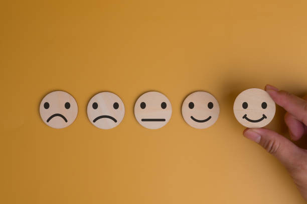 istock Hand wood block circle chooses icon smile face Customer service evaluation and satisfaction survey concepts on yellow background. copy space 1628747372