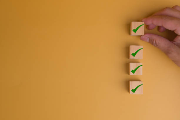 istock human hand putting cube wood with Check mark icon on yellow background with copy space Checklist concept. 1628747905