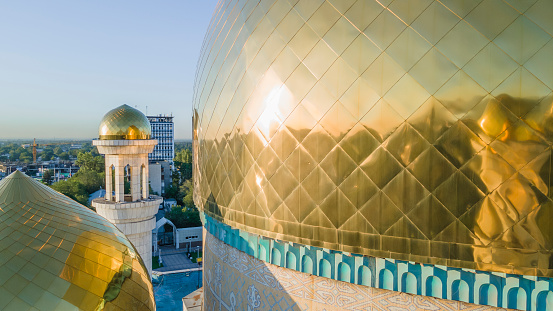Almaty, Kazakhstan - August 17, 2023: The golden dome and minaret of the mosque. The central mosque