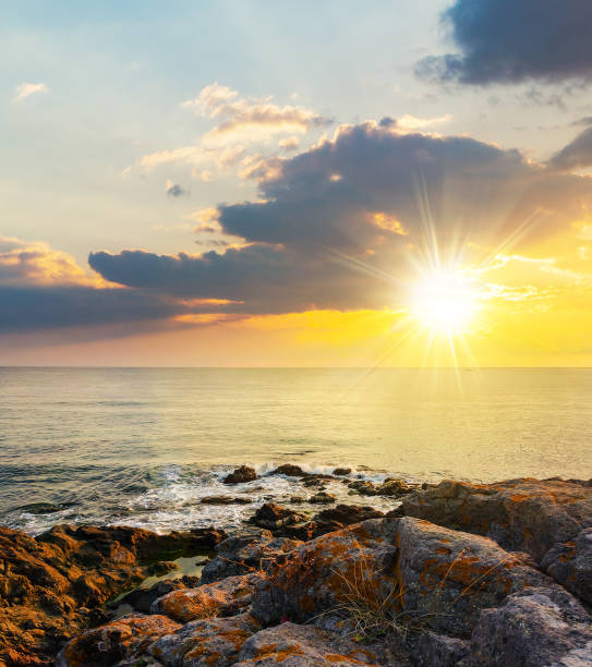 istock sea wave breaks about rocky shore at sunset 1628752846