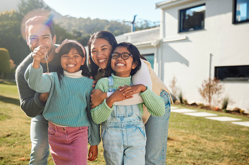 In this heartwarming moment, a family of four radiates with joy as they embrace the milestone of their new home. With beaming smiles and arms wrapped around each other, they stand in front of their new house, capturing a poignant tableau that symbolizes the excitement, unity, and new beginnings that come with creating a cherished home together.