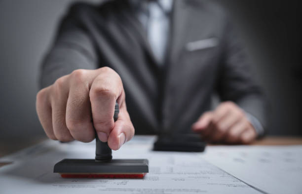 istock Closed up businessman hand using wooden stamping to document approve and reject document or project concept, copy space. 1628794235