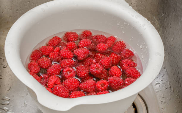 istock Rinsing raspberry fruit in water, with the addition of baking soda 1628824740