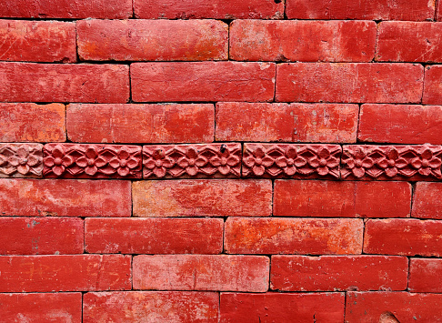 Red brick wall background decorated with flower. Wall background.