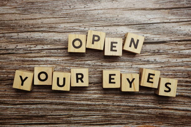 istock Open your eyes alphabet letters on wooden background 1628846077
