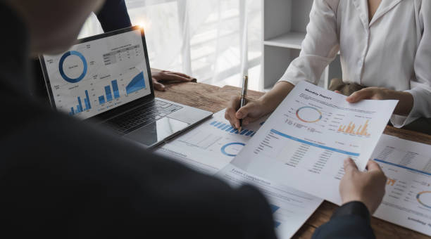 istock Business People Meeting using laptop computer,calculator,notebook,stock market chart paper for analysis Plans to improve quality next month. Conference Discussion Corporate Concept. 1628850405