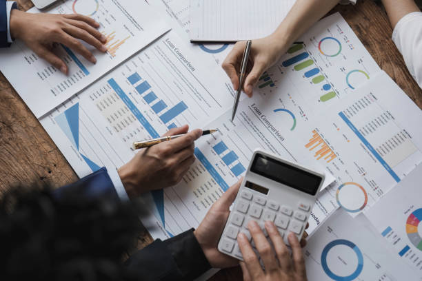 istock Business People Meeting using laptop computer,calculator,notebook,stock market chart paper for analysis Plans to improve quality next month. Conference Discussion Corporate Concept. 1628850966