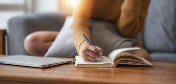 istock Close up of female hands who write in a notebook. Work at home 1628852762