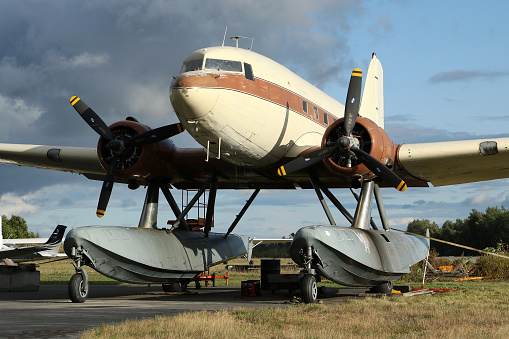 A privately owned 1943 Douglas DC-3 equipped with Amphibious Floats (the only such type in the world)  parked on the grass at the Greenville Municipal Airport in Maine, USA.
