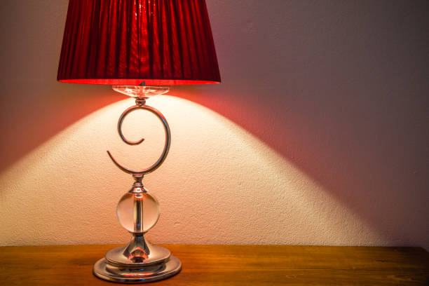 Vintage lamp on wooden table with white wall background copy space. Home decor, lighting equipment concept.