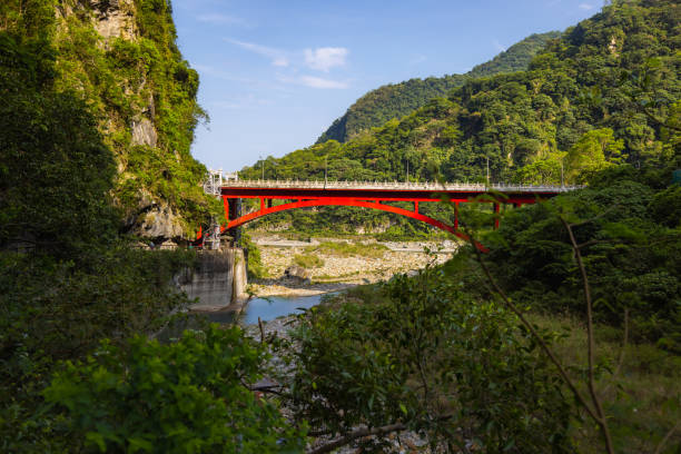 puente shakadang sobre el río liwu en la entrada del sendero shakadang, una de las muchas rutas de senderismo impresionantes en el parque nacional taroko taiwán. el puente de acero rojo cruza el arroyo cristalino - parque nacional de gorge taroko fotografías e imágenes de stock