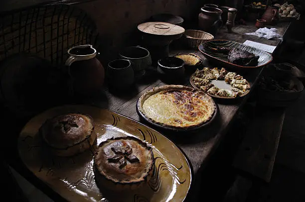 A representative and authentic display of food prepared by servants in a 16th century manor house kitchen, ready to be taken to the gentry in the great hall.  Pies, flans, pancakes and roast meat provide a suitable daily feast for the wealthy owners of the manor and surrounding land.  Suffolk, England, 2011.