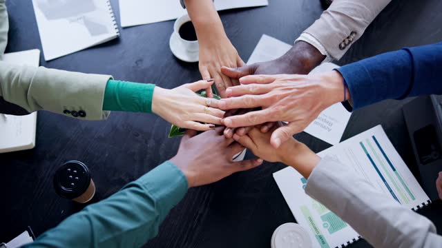 Business meeting, people and hands together for teamwork, support or collaboration on project goals, success and celebration. Circle planning, motivation and group or team with stack sign above table