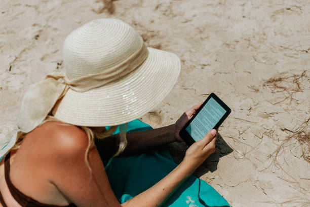 istock Woman Relaxing at Beach on Chair with Electronic Book Reader 1628914617